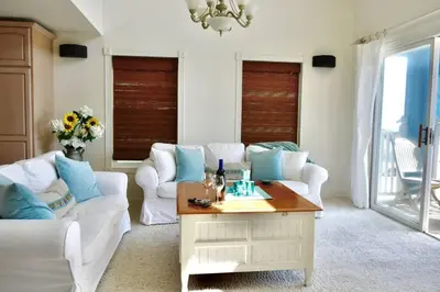 a living room with white furniture and blue pillows at Beach House located in quiet community. in Oxnard