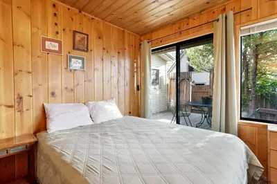 a bed in a wooden room with a window at Pine Nest Relaxing Walk to Marina Cozy Chalet in Big Bear Lake