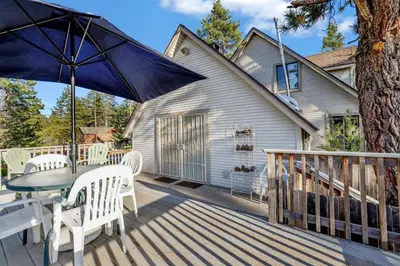 a patio with a table and chairs and an umbrella at Pine Nest Relaxing Walk to Marina Cozy Chalet in Big Bear Lake