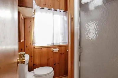a bathroom with a toilet and a window and a shower at Pine Nest Relaxing Walk to Marina Cozy Chalet in Big Bear Lake