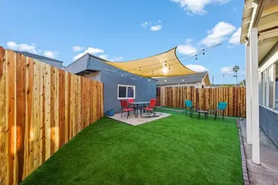 a backyard with a wooden fence and green grass at Spacious Centrally Located NEW 2 Bedroom Property! in Inglewood