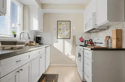 a white kitchen with white cabinets and a sink at Spacious Centrally Located NEW 2 Bedroom Property! in Inglewood