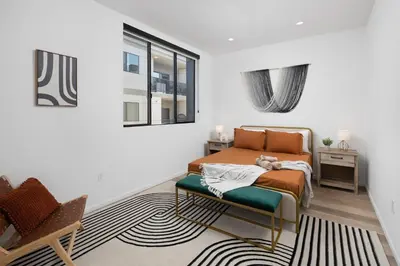 a bedroom with a bed and a table and a window at Modern Hollywood Charm in Los Angeles