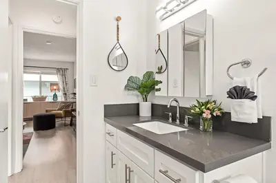 a white bathroom with a sink and a mirror at East Village Arts District, King Suite with Sofa Bed NRP23-01221 in Long Beach
