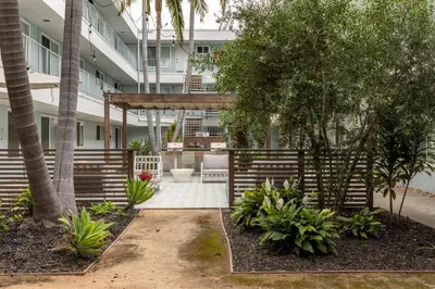 a garden with a pergola in front of a building at East Village Arts District, King Suite with Sofa Bed NRP23-01221 in Long Beach