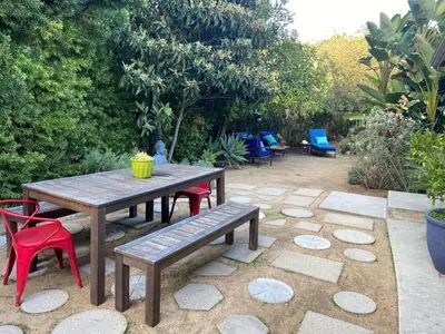 a picnic table with chairs and a bench in a garden at Stunning Hollywood Midcentury Modern-Views-Best Location! in Los Angeles