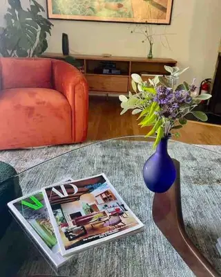 a table with a vase with flowers and a magazine at Stunning Hollywood Midcentury Modern-Views-Best Location! in Los Angeles