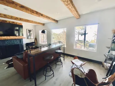 a living room with a bar and a fireplace at The Inspo Cabin with Stunning View in Running Springs