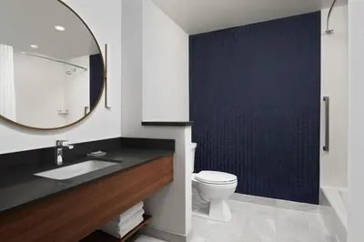 a bathroom with a sink and a toilet and a mirror at Fairfield by Marriott Inn & Suites Chino in Chino