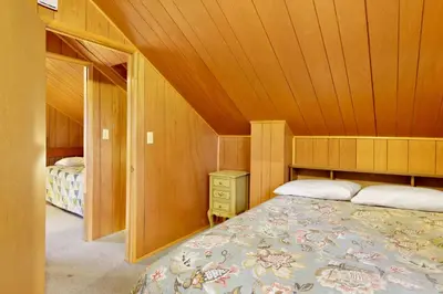 a small bedroom with a bed and a wooden ceiling at Pinglewood Cabin- Furnished Fawnskin Group Retreat in Fawnskin