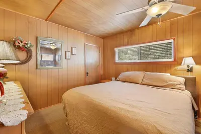 a bedroom with a bed and a ceiling fan at Pinglewood Cabin- Furnished Fawnskin Group Retreat in Fawnskin