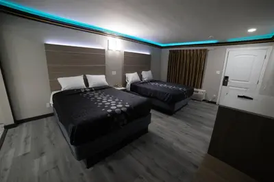 a hotel room with two beds and a tv at Artesia Motor Inn in Bellflower