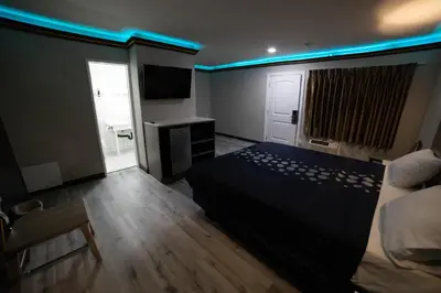 a bedroom with a bed and a blue light at Artesia Motor Inn in Bellflower