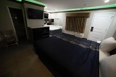 a hotel room with a bed and a television at Artesia Motor Inn in Bellflower
