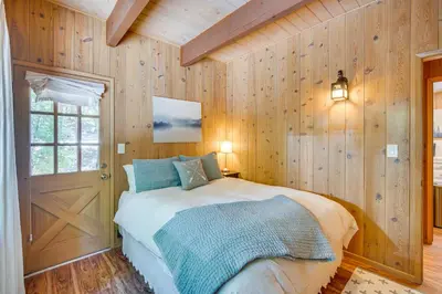 a bedroom with wooden walls and a bed in a room at Steps to Lake Arrowhead Cabin with Full Lake Access in Lake Arrowhead
