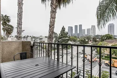 a table on a balcony with a view of a city at West LA 2br w rooftop courtyard LAX-1055 in Los Angeles