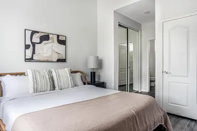 a white bedroom with a bed and a mirror at West LA 2br w rooftop courtyard LAX-1055 in Los Angeles