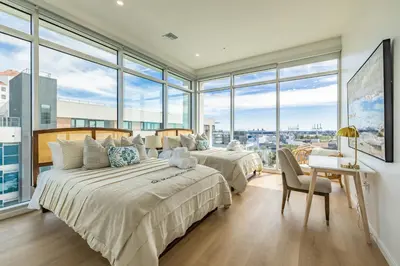 two beds in a bedroom with large windows at @ Marbella Lane - Sleek Corner Ocean View in Long Beach