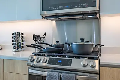 a kitchen with a stove with pots and pans on it at @ Marbella Lane - Sleek Corner Ocean View in Long Beach