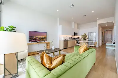 a living room with a green couch and a table at @ Marbella Lane - Sleek Corner Ocean View in Long Beach