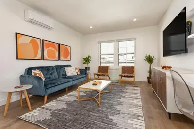 a living room with a blue couch and a tv at Downtown Culver City New Designer Lux 1 Bedroom in Los Angeles