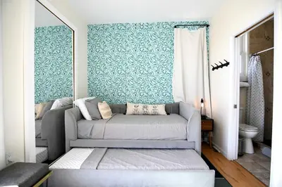a couch in a living room with blue wallpaper at Ocean View Hot Tub Luxe House Steps to Sand in Hermosa Beach