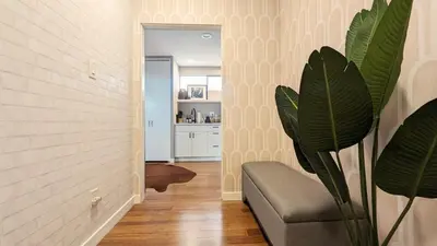 a living room with a chair and a plant at LA Huge Mid Century Guesthouse Patio LAX Beach in Los Angeles