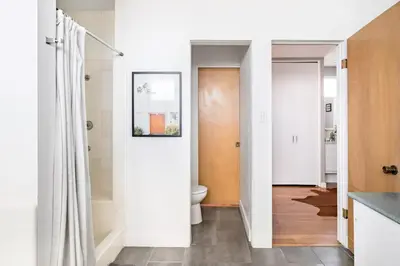 a bathroom with white walls and a toilet at LA Huge Mid Century Guesthouse Patio LAX Beach in Los Angeles