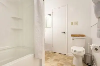 a white bathroom with a toilet and a shower at Downtown Manhattan Beach 3 Bed Townhouse Parking in Manhattan Beach