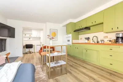 a kitchen with green cabinets and a table at Steps to Beach Manhattan Beach 2 Bedroom Parking in Manhattan Beach