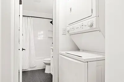 a small white bathroom with a washer and dryer at Double King Suite with Patio Dining and Parking NRP21-00386 in Long Beach