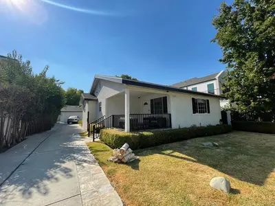 a white house with a fence and a yard at Charming Bright Traditional Home in Sherman Oaks in Sherman Oaks