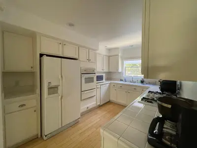 a kitchen with white cabinets and a white refrigerator at Charming Bright Traditional Home in Sherman Oaks in Sherman Oaks
