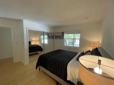 a bedroom with a large bed and a mirror at Charming Bright Traditional Home in Sherman Oaks in Sherman Oaks
