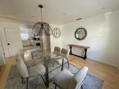 a living room with a table and chairs and a mirror at Charming Bright Traditional Home in Sherman Oaks in Sherman Oaks