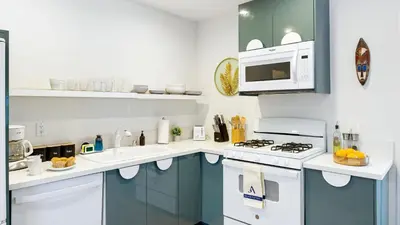 a kitchen with blue cabinets and a white stove top oven at Urban Jungle by AvantStay in Los Angeles