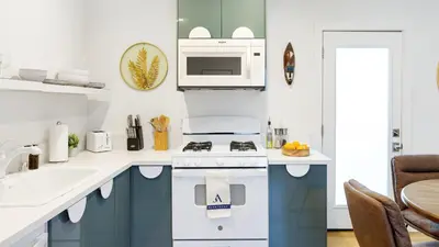 a white kitchen with a stove and a sink at Urban Jungle by AvantStay in Los Angeles