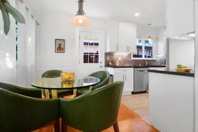 a kitchen with a glass table and green chairs at Villa La Verde - Newly Designed 4BR Villa with Pool & Guesthouse by Topanga in Los Angeles