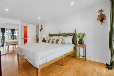 a bedroom with a large bed with a wooden floor at Villa La Verde - Newly Designed 4BR Villa with Pool & Guesthouse by Topanga in Los Angeles
