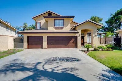 a house with a large driveway in front of it at Families/Digital Nomads/Corporate Housing in Bakersfield