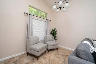 a living room with two chairs and a window at Families/Digital Nomads/Corporate Housing in Bakersfield