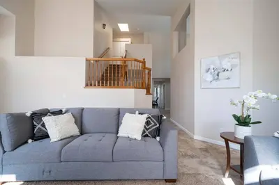 a living room with a blue couch and a table at Families/Digital Nomads/Corporate Housing in Bakersfield