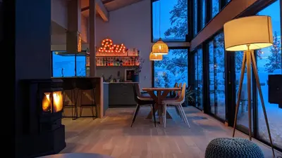 a living room with a fireplace and a table with chairs at Spectacular Designer Treehouse with Mountain Views in Pine Mountain Club