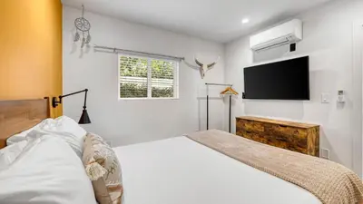 a bedroom with a bed and a flat screen tv at Southwest by AvantStay in Los Angeles