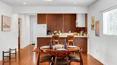a kitchen with a wooden table and chairs in a room at Southwest by AvantStay in Los Angeles