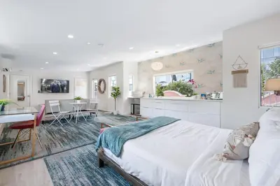 a white bedroom with a large bed and a kitchen at Day Dreams by AvantStay in Los Angeles