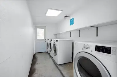 a laundry room with three washing machines in it at Day Dreams by AvantStay in Los Angeles