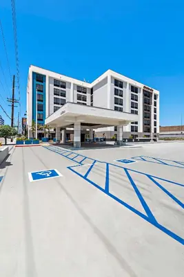 a large white building with blue lines in front of it at Hampton Inn Los Angeles Airport in Los Angeles