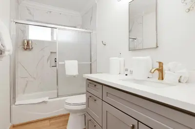 a white bathroom with a sink and a shower at Sweet Retreat 1- Cozy Relaxing Resort Cabin in Big Bear Lake