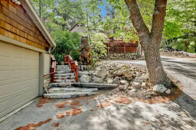 a house with a bear statue next to a driveway at Knickerbocker Retreat- Hot Tub- Game Tables in Big Bear Lake